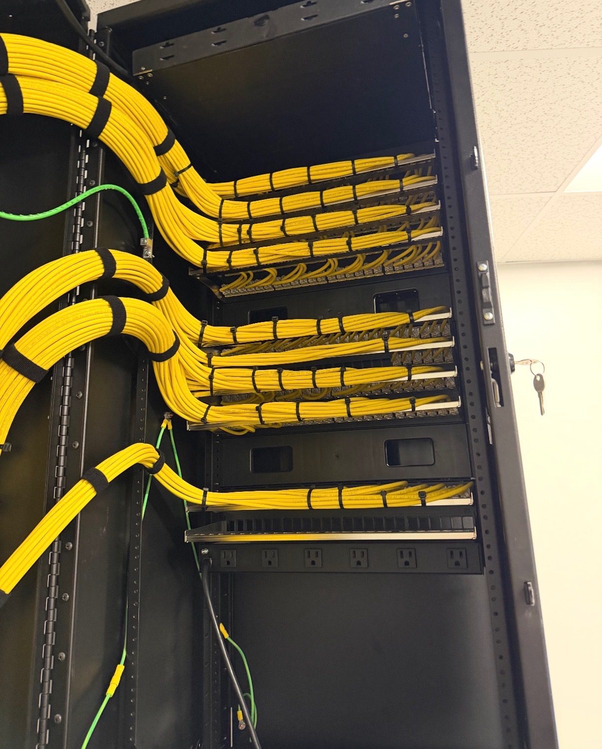Yellow fiber cables dressed into a rack and terminated at patch panels